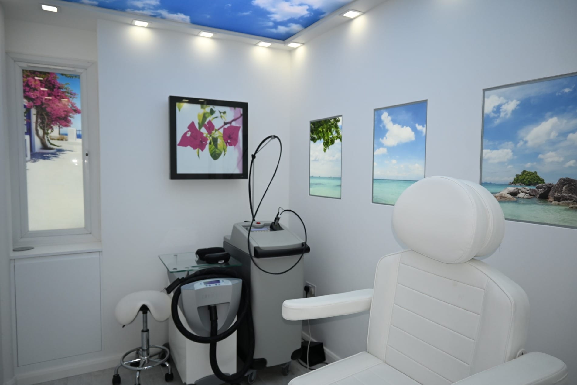 Laser clinic room with a treatment chair and framed beach pictures