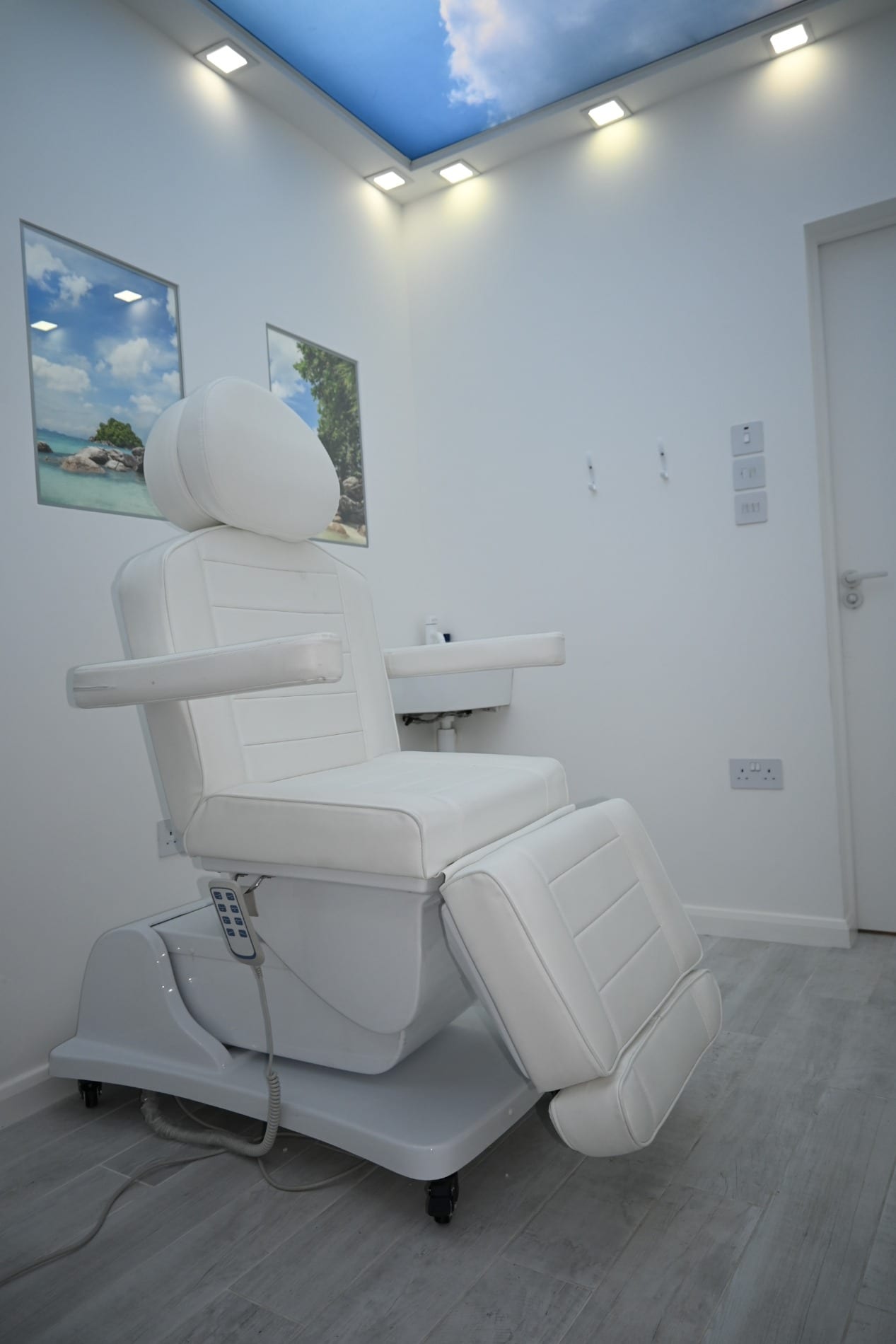 Reclining treatment chair beneath a blue sky ceiling panel