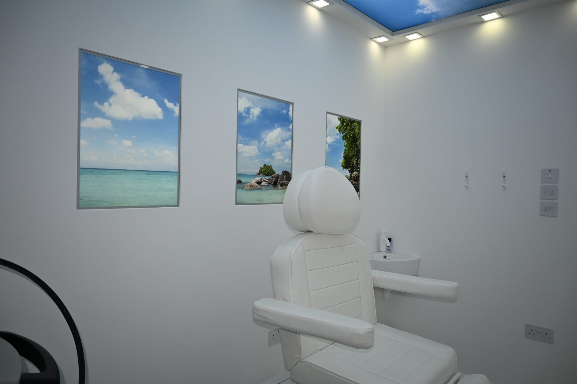 Treatment chair against a wall with framed beach pictures