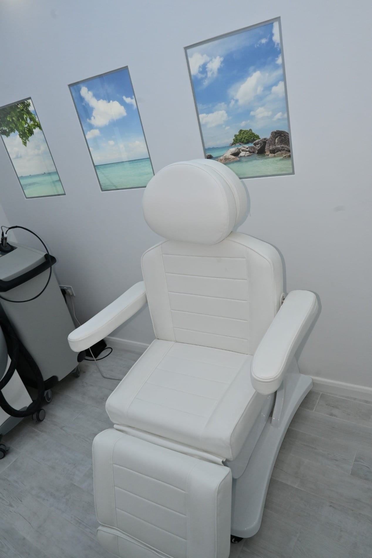 White treatment chair with framed beach pictures behind